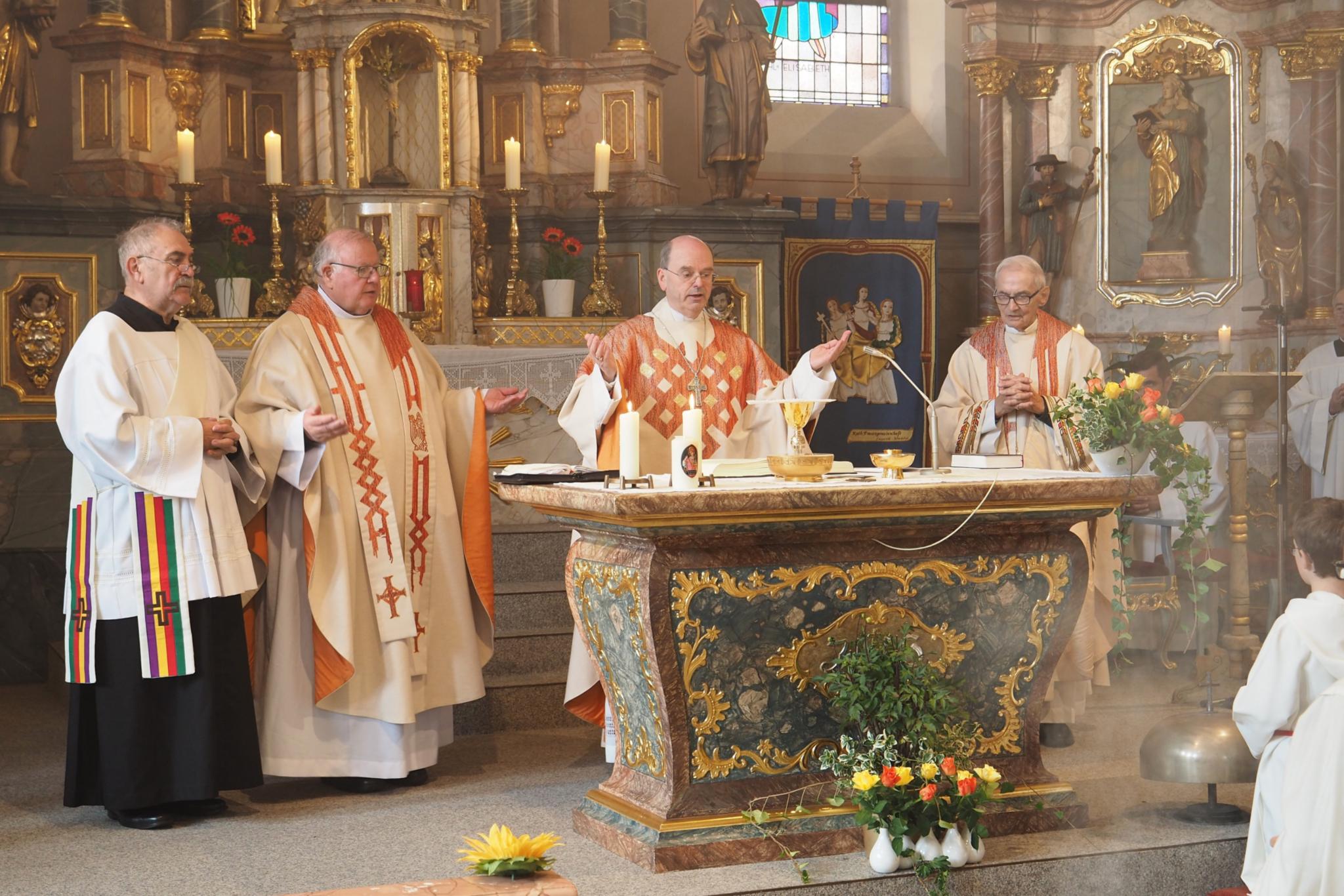 Diakon Karl Weyandt, Pfarrer Georg Josef Müller, Weihbischof Robert Brahm und der Ruhestandsgeistliche Pfarrer Friedrich Kreutz (von links) feiern das Hochamt am Altar der Pfarrkirche St. Johannes der Täufer. (Foto: Stefan Endres/Bistum Trier)