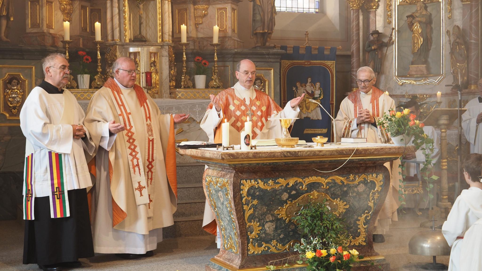 Diakon Karl Weyandt, Pfarrer Georg Josef Müller, Weihbischof Robert Brahm und der Ruhestandsgeistliche Pfarrer Friedrich Kreutz (von links) feiern das Hochamt am Altar der Pfarrkirche St. Johannes der Täufer. (Foto: Stefan Endres/Bistum Trier)